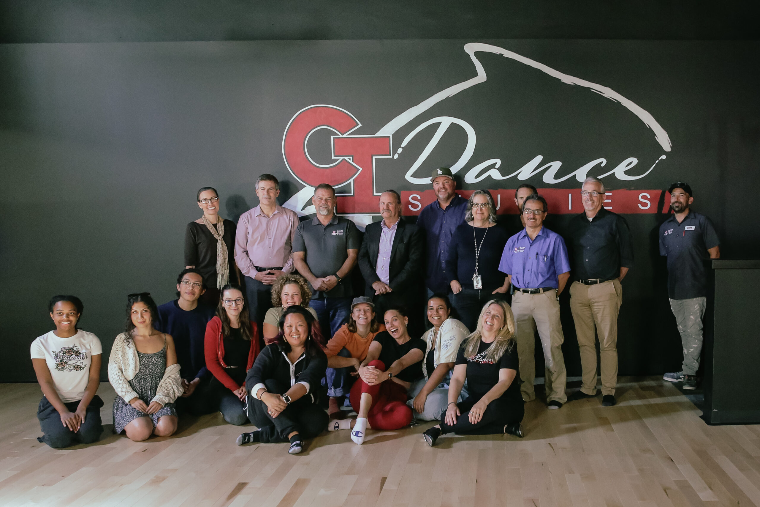 People sitting in front of CI Dance Studies Graphic in Malibu Hall 120 post ribbon cutting ceremony
